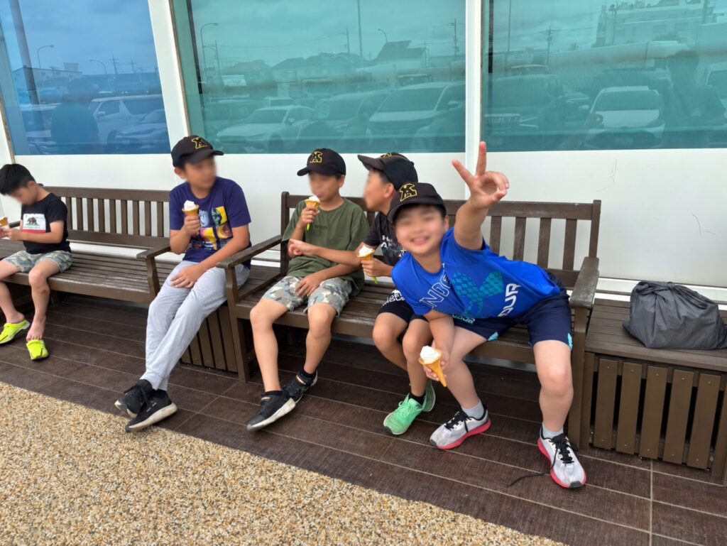 ソフトクリームを持って元気にピースする選手