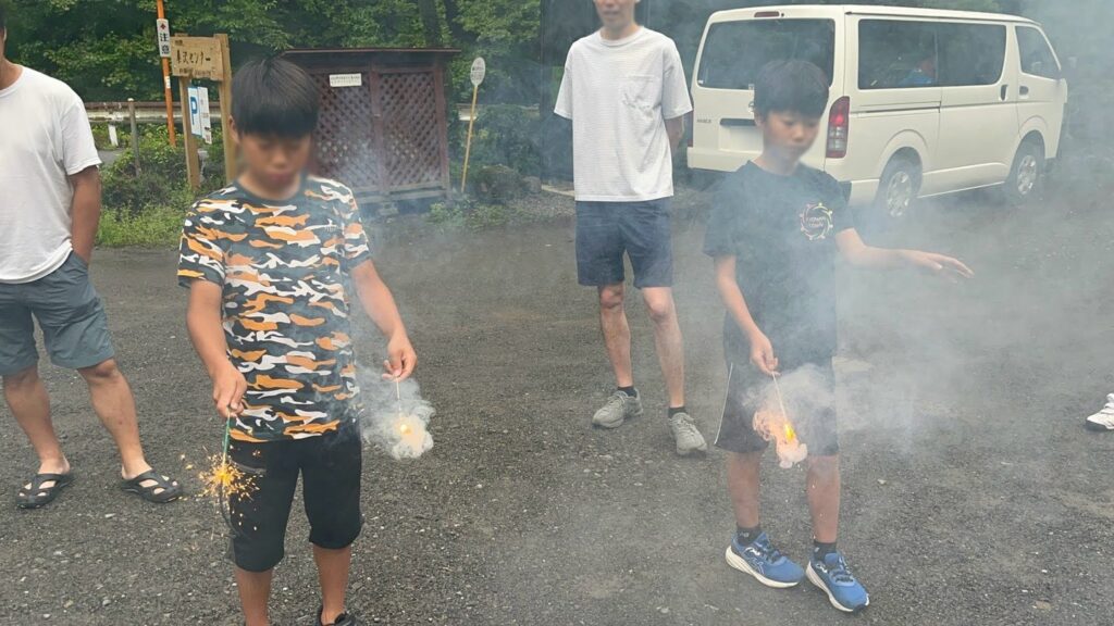 仲間と並んで手持ち花火を楽しむ選手たち